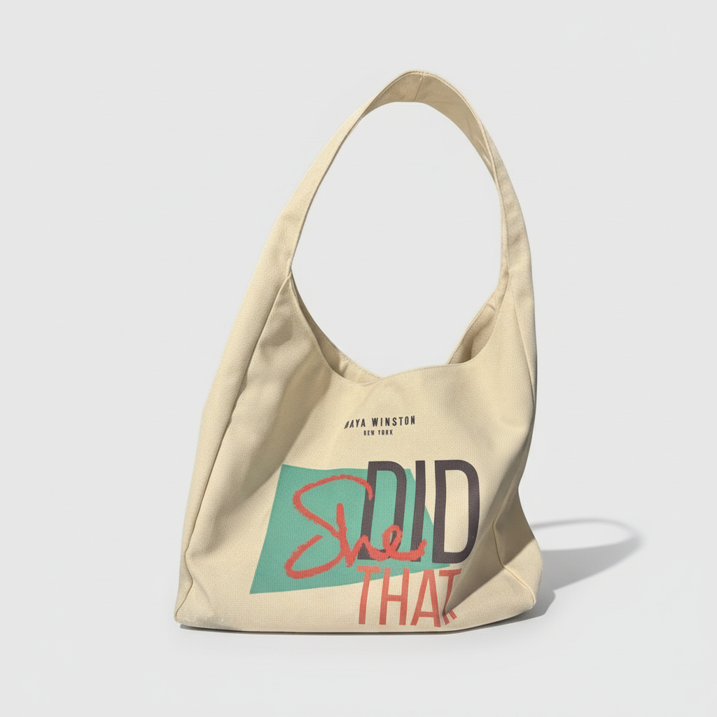 Beige tote bag with 'She Did That' text on a white background