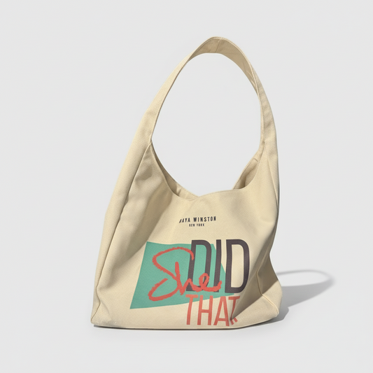 Beige tote bag with 'She Did That' text on a white background